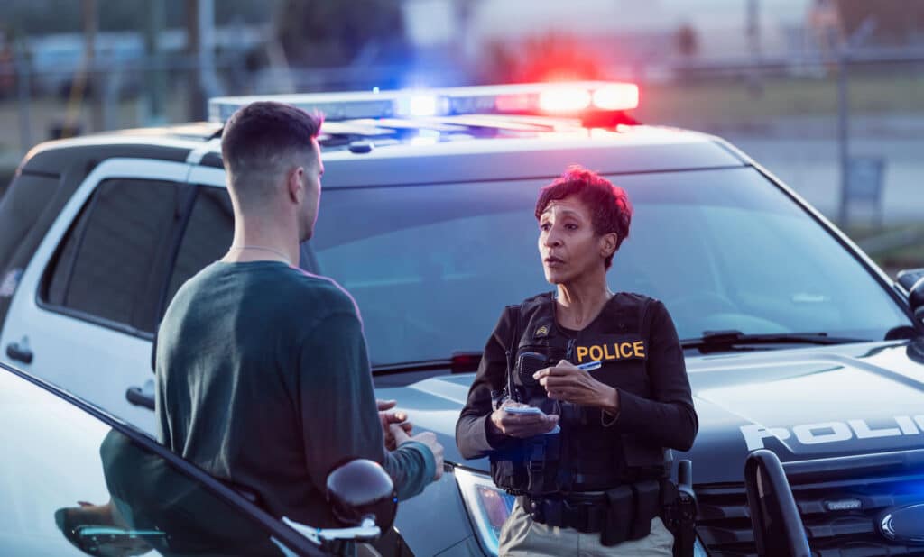 image of a Texas police officer writing ticket to male civilian