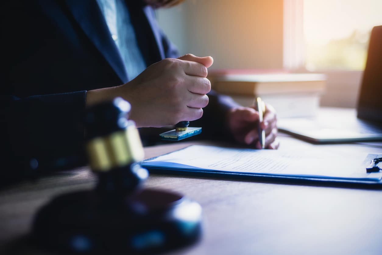 Attorney reviewing case documents beside a judge gavel during a client consultation