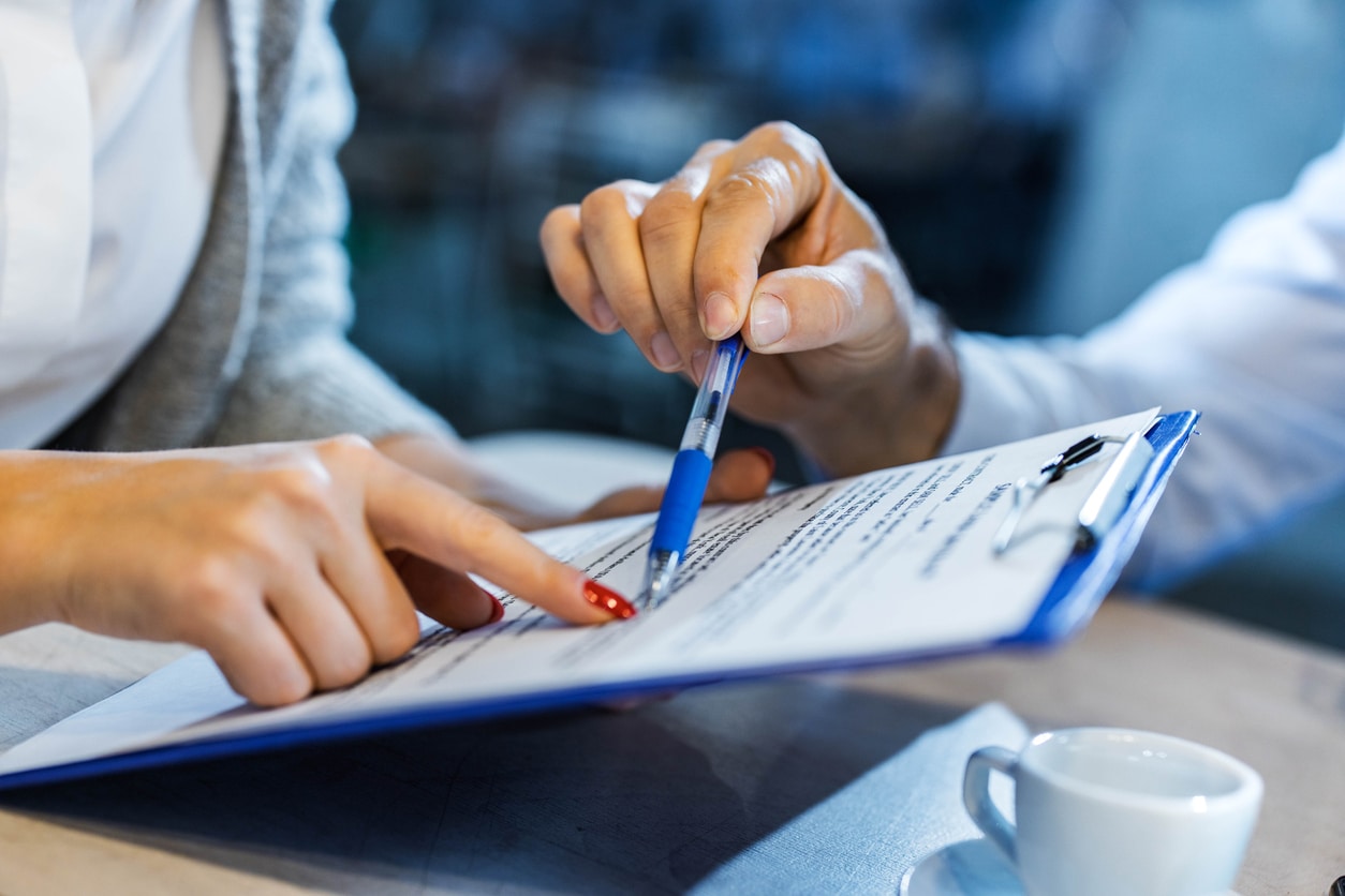 Client signing a legal representation agreement with a pen