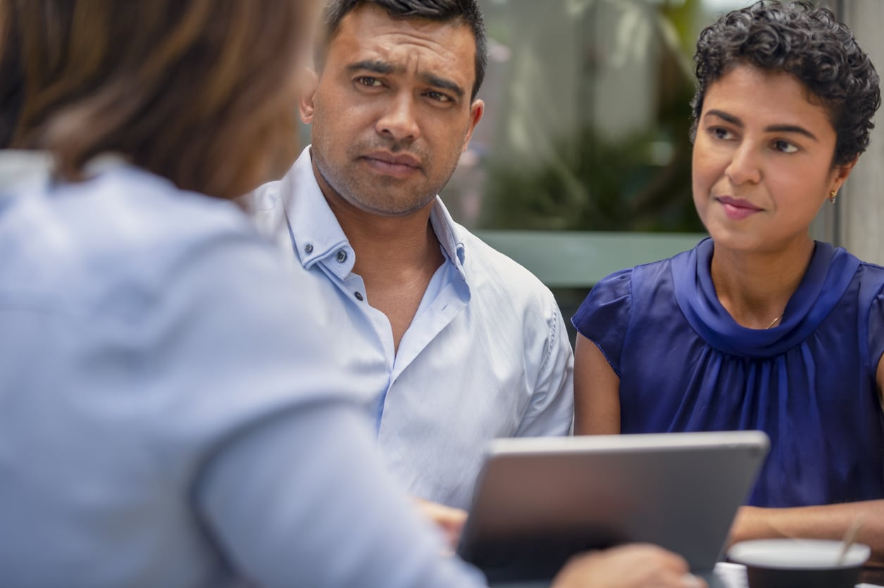 Concerned couple having a business meeting with a financial advisor.